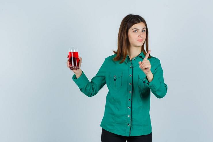با این مواد غذایی کبدتان را سم زدایی کنید young girl holding glass red liquid showing warning gesture green blouse black pants looking cute front view 176474 67219 - با این مواد غذایی کبدتان را سم زدایی کنید